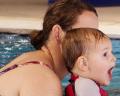 A woman and a child are enjoying time together in a swimming pool, showcasing a joyful and playful atmosphere.