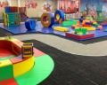 A colorful indoor play area filled with soft blocks, climbing structures, and a winding pathway, designed for children's play and exploration.