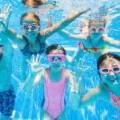 Four young swimmers underwater smiling.