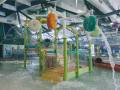 A large water area with green, orange and yellow water buckets and activities.