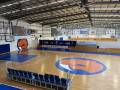 A large multi court basketball stadium with the logo in the middle of the court.