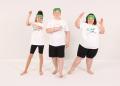 Three kids in green headbands and white shirts strike playful poses against a plain backdrop, showcasing joy and teamwork.